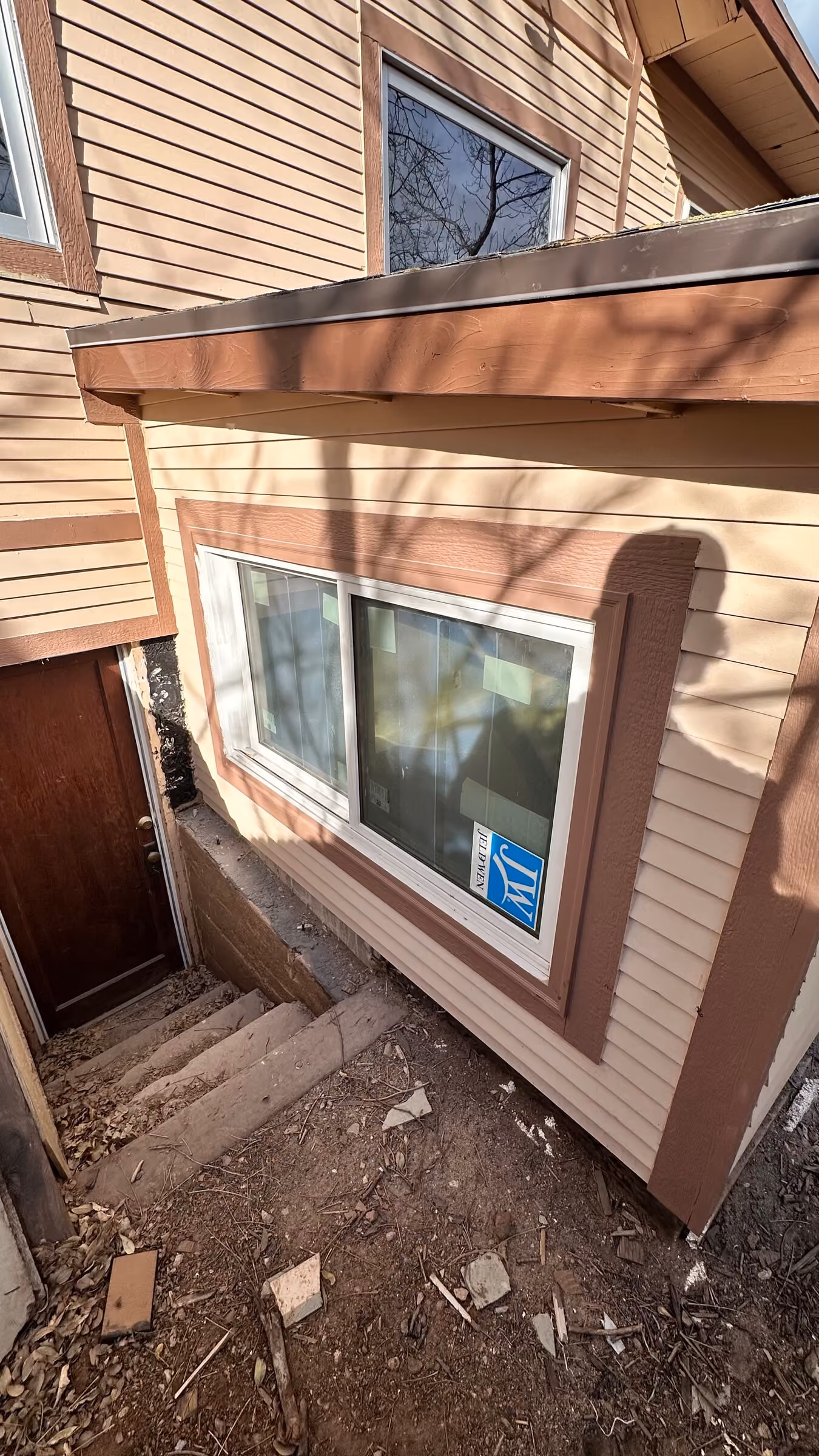 Paired windows, siding, trim, and roof edge on the completed addition