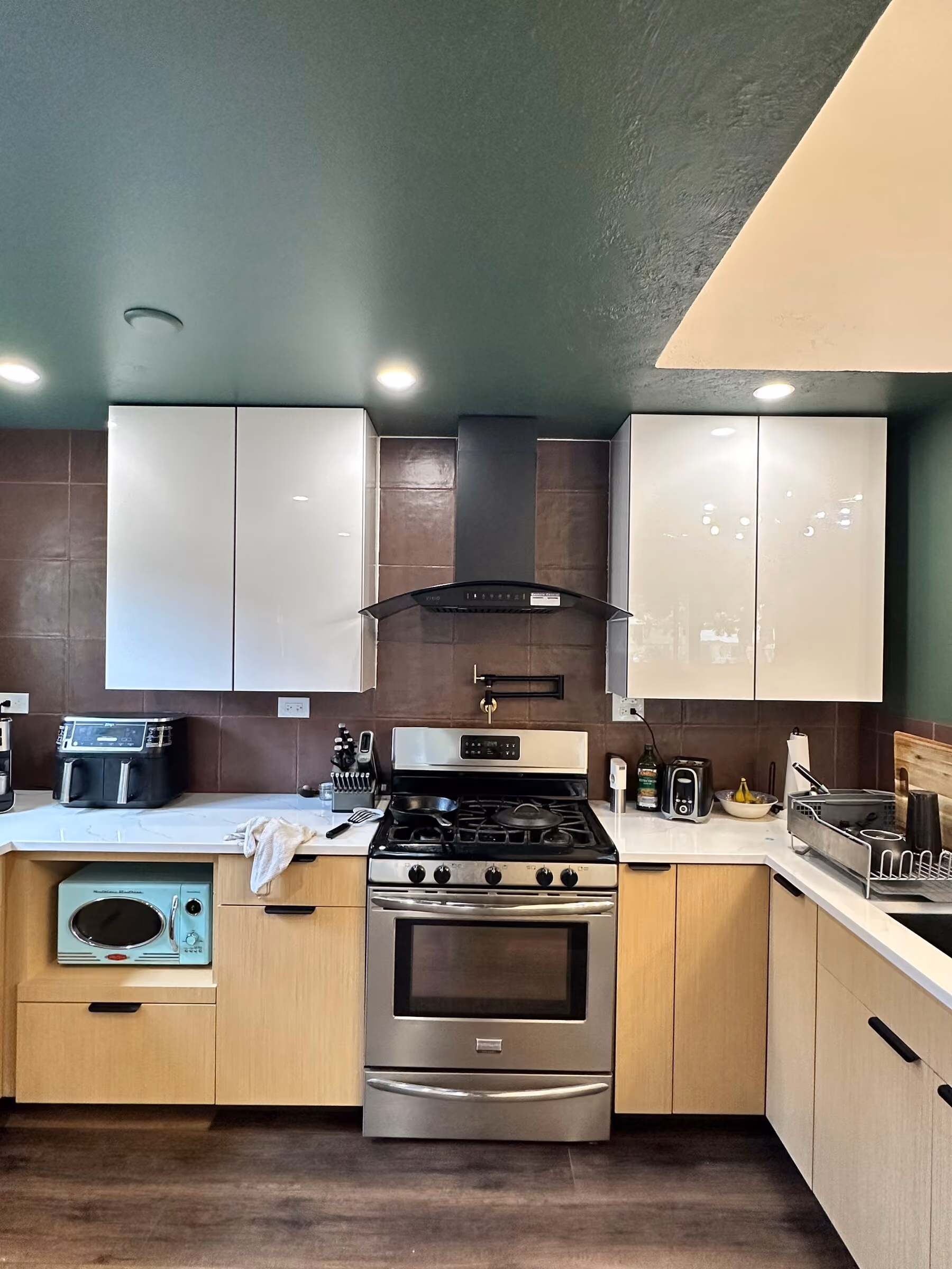 Range, hood, cabinetry, and backsplash detail in the renovated kitchen
