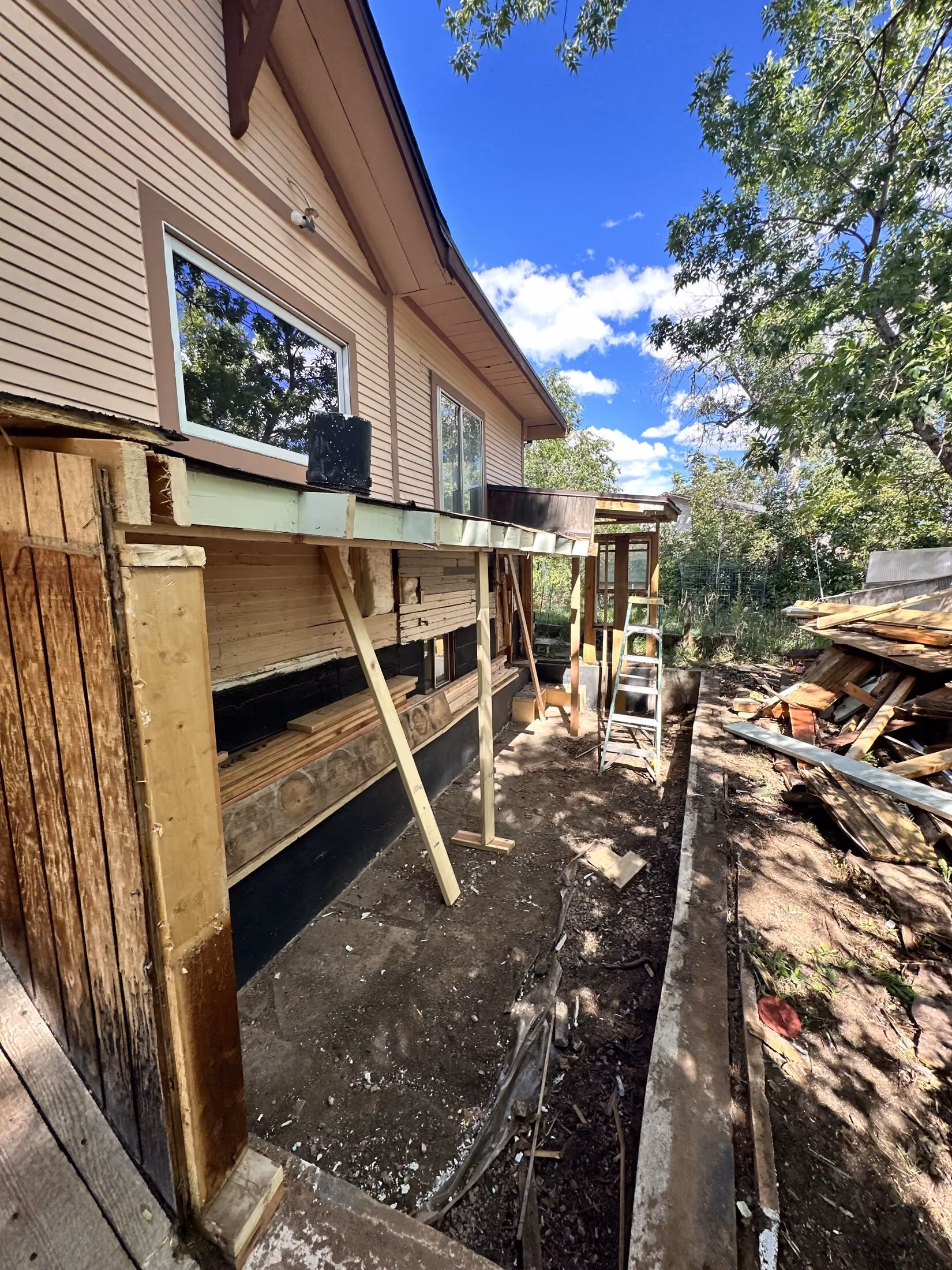 Excavation and exposed wall framing during addition demolition