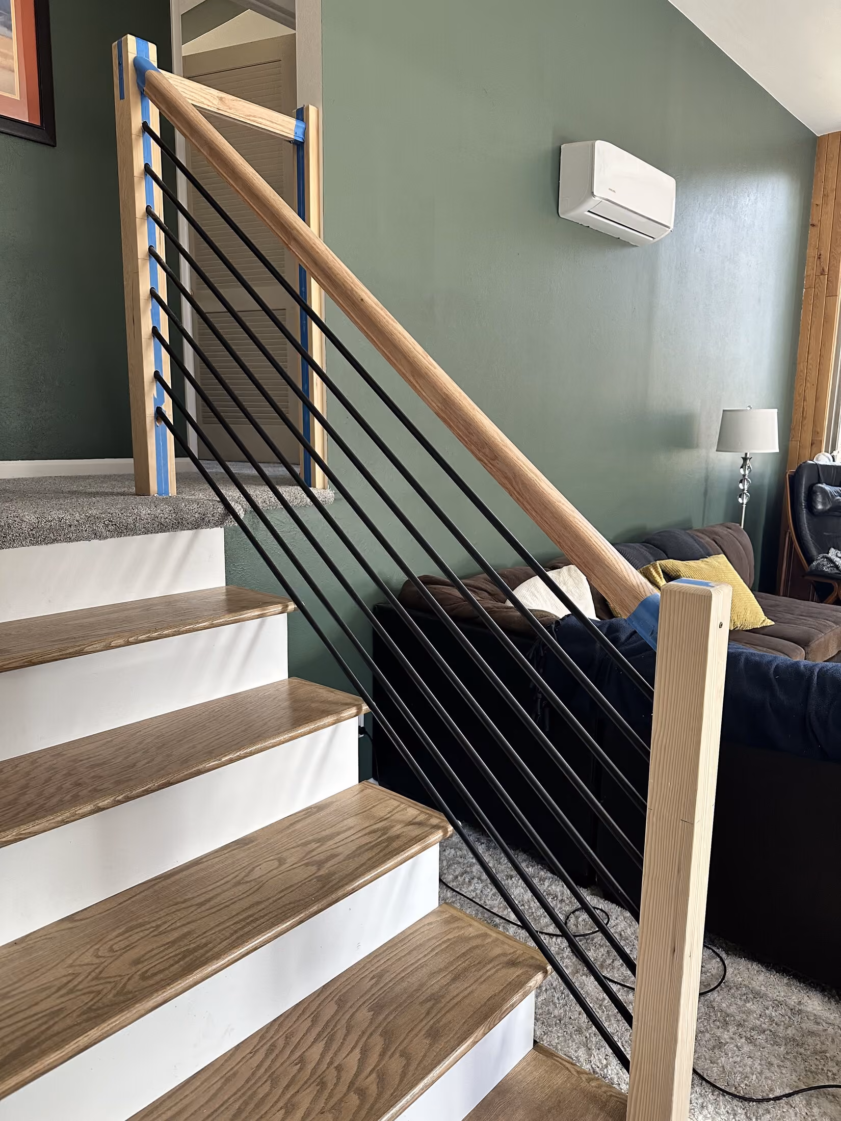 Custom wood handrail and metal balusters during installation