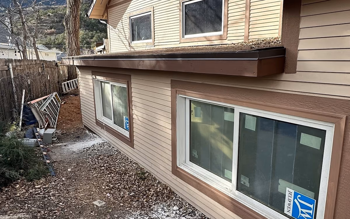 Completed Manitou Springs addition exterior with new windows, siding, and a low-slope roof
