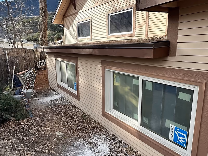 Completed Manitou Springs addition exterior with new windows, siding, and a low-slope roof