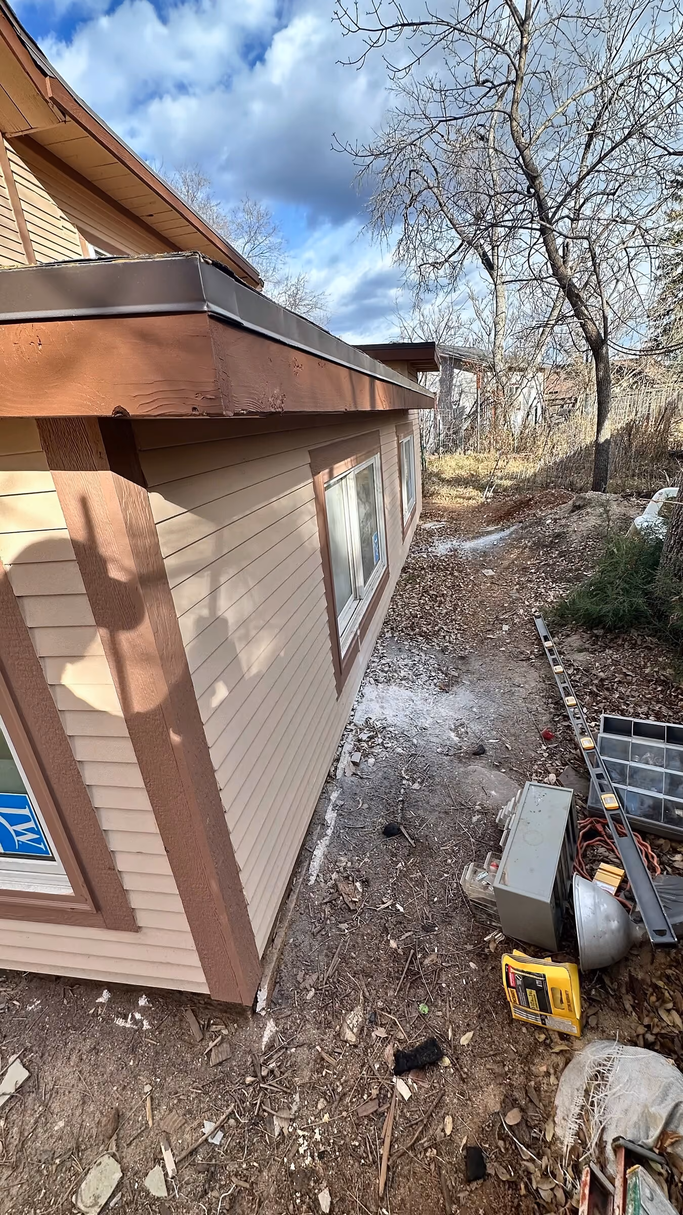 Completed side wall and low-slope roof where the addition meets the existing house