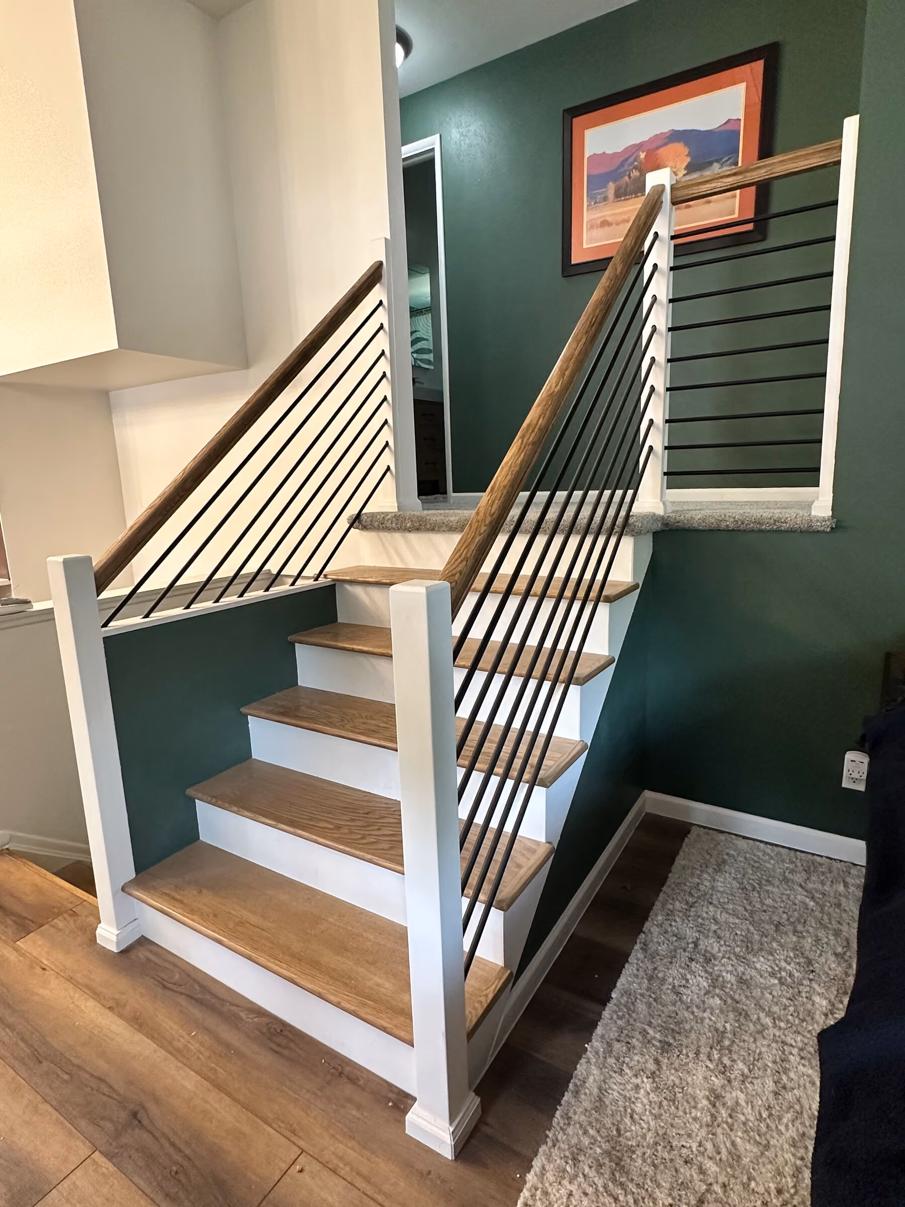 Custom Pleasant Valley staircase with wood treads, railing, and metal balusters